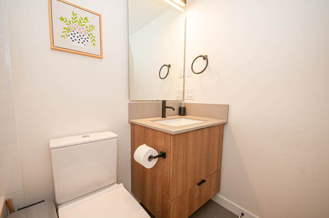Furnished bathroom with wooden accents and a modern sink. - 30 - 533 East 3rd st., North Vancouver