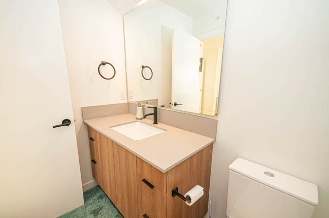Furnished bathroom with wooden countertops and a large mirror. - 30 - 533 East 3rd st., North Vancouver