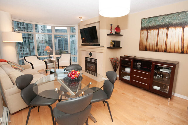 Spacious living room with hardwood floors, city view, and modern furniture. - 1605 - 1199 Marinaside Crescent, Vancouver Downtown