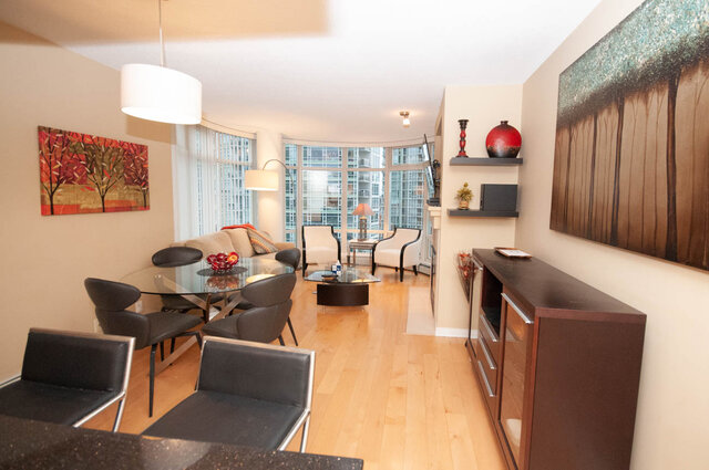 Modern open-concept living room with hardwood floors, city view, and contemporary decor. - 1605 - 1199 Marinaside Crescent, Vancouver Downtown