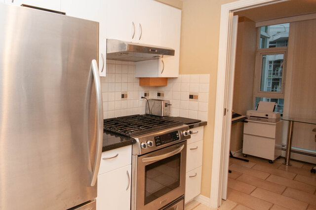 Bright kitchen with stainless steel appliances and white cabinetry, featuring a gas stove and modern counter space.
