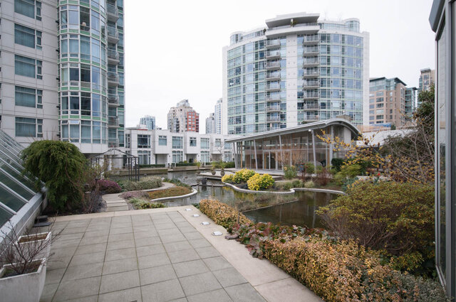 Spacious 1-bedroom + den condo with a serene rooftop garden featuring a pond and lush greenery. - 1605 - 1199 Marinaside Crescent, Vancouver Downtown