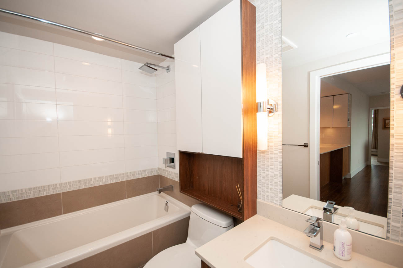 Furnished bathroom with white countertops, wooden accents, and a modern sink setup. - 1403 - 159 West 2nd, Vancouver West Side