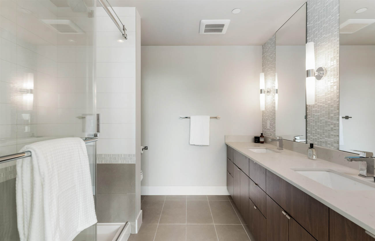Furnished bathroom with modern vanity, large mirror, and sleek lighting. - 1403 - 159 West 2nd, Vancouver West Side