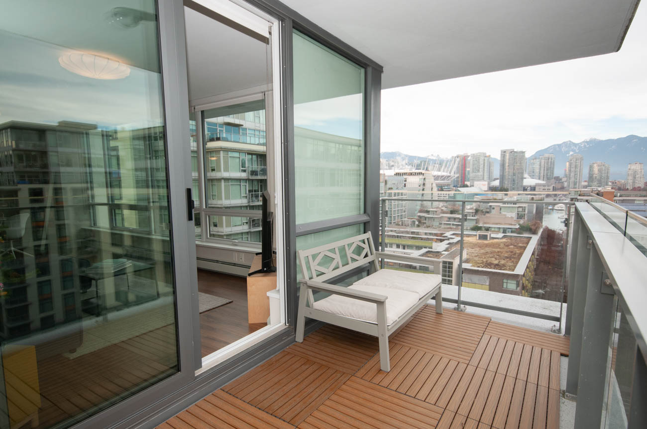 Furnished balcony with sliding glass doors, hardwood flooring, and city views. - 1403 - 159 West 2nd, Vancouver West Side