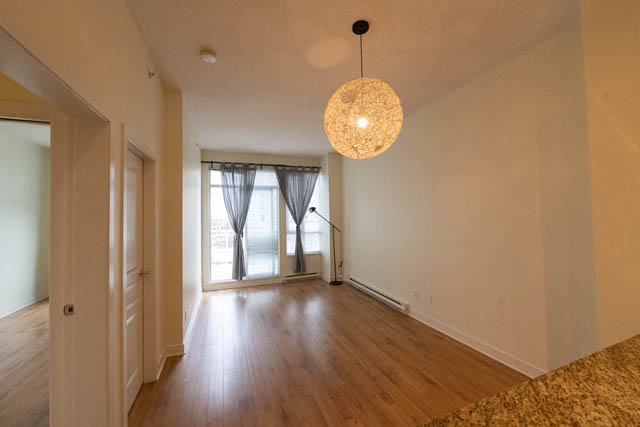 Bright living area with hardwood floors and a woven pendant light. - 807 - 4078 Knight Street, Vancouver East Side