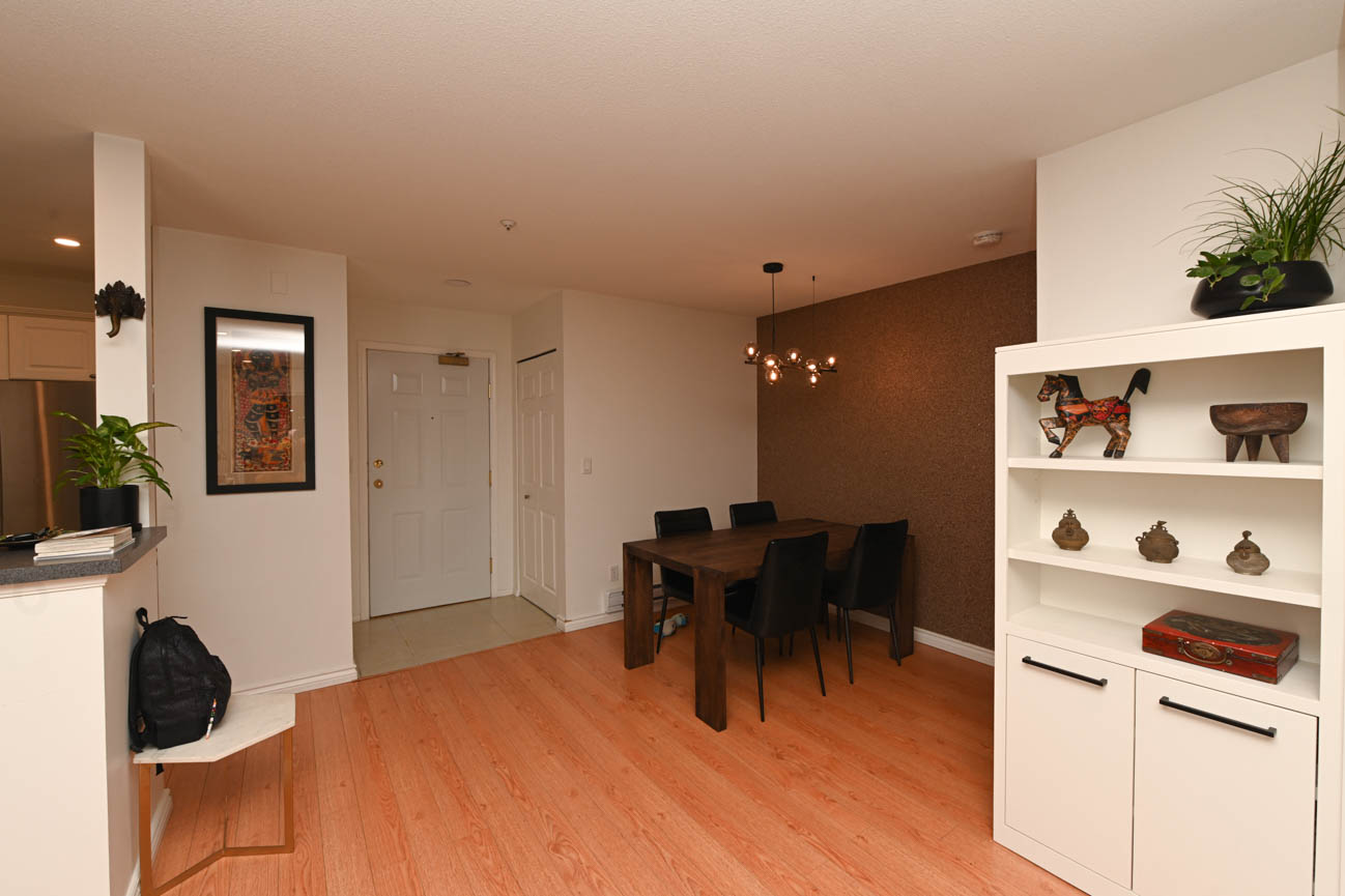 Furnished dining area with hardwood floors and modern decor. - 208-128 8th Street West, North Vancouver