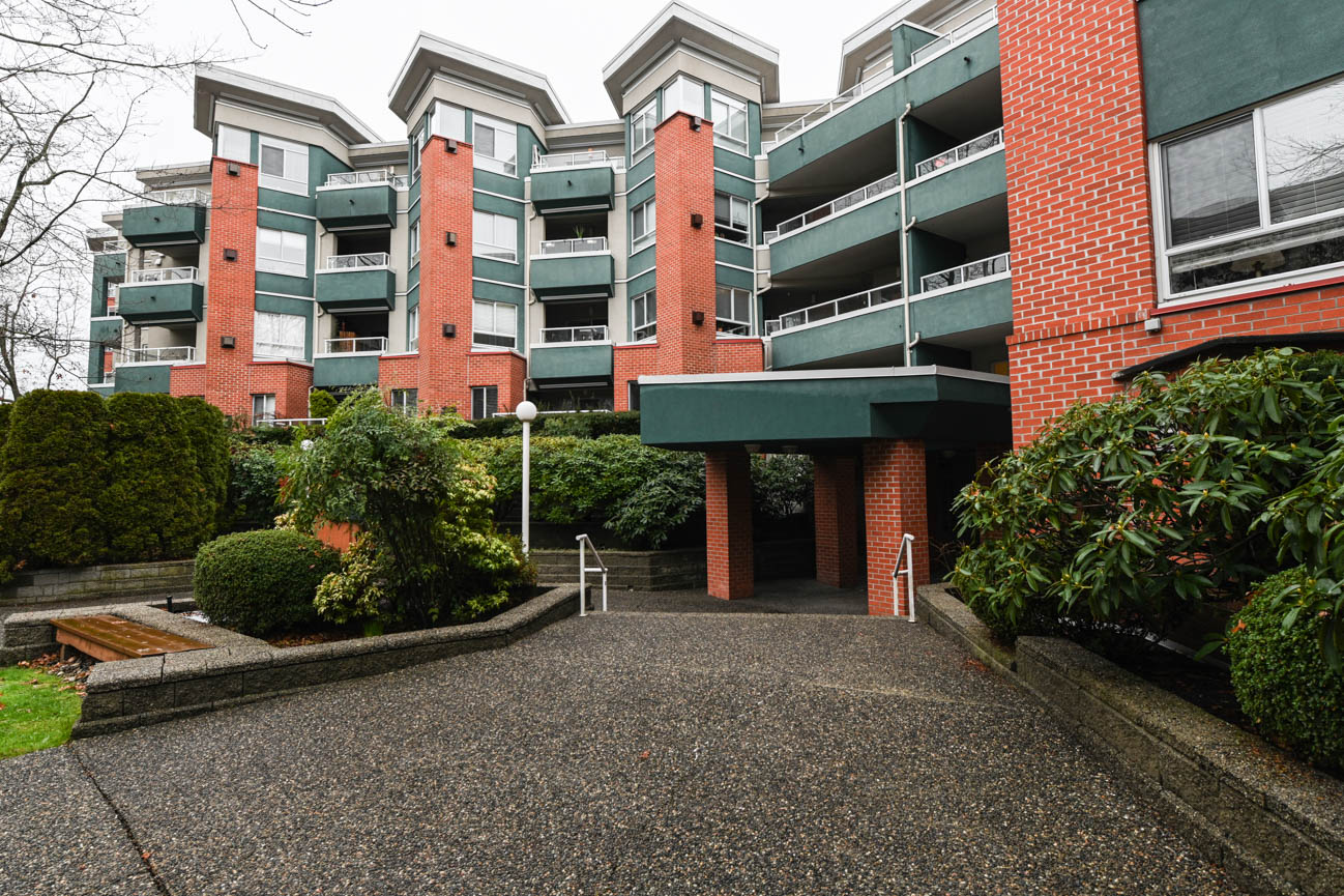 Furnished 2-bedroom condo with brick facade and green balconies. - 208-128 8th Street West, North Vancouver