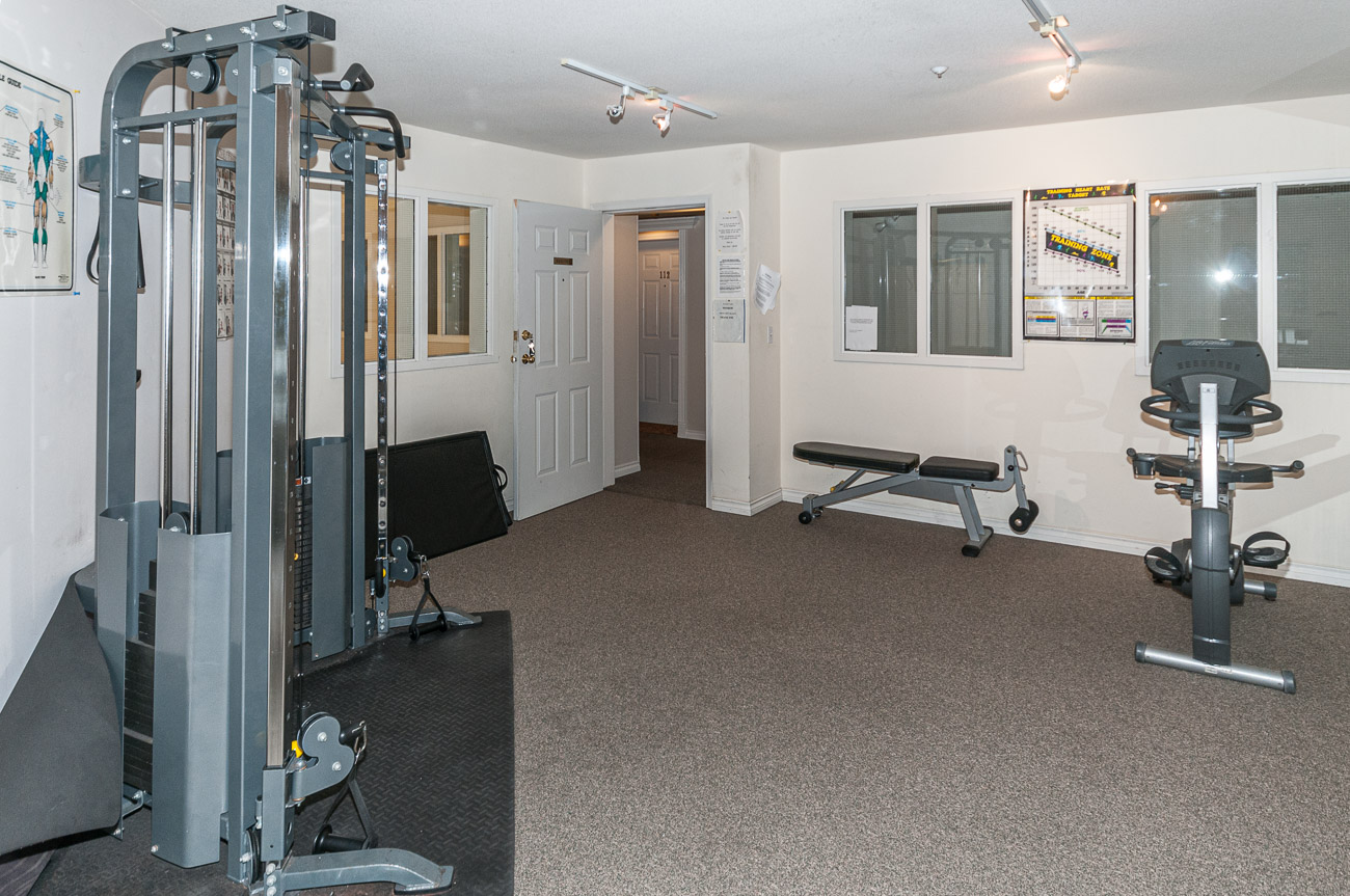 Fitness room with cardio equipment and workout bench. - 208-128 8th Street West, North Vancouver