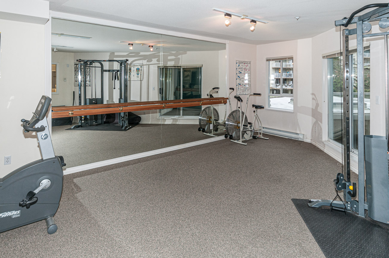 Bright exercise room with mirrored walls and cardio equipment. - 208-128 8th Street West, North Vancouver