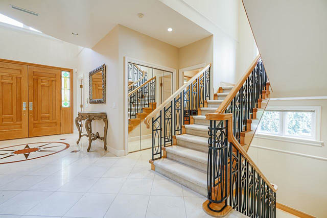 Foyer with marble floor, wooden doors, and wrought iron staircase. - 1128 W 49th, Vancouver West Side