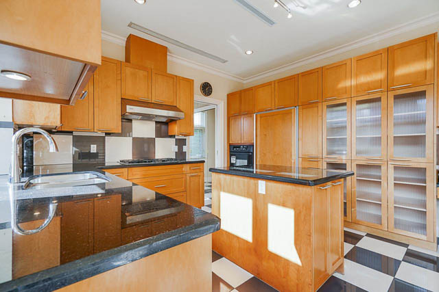 Bright kitchen with modern cabinets, granite countertops, and a large window. - 1128 W 49th, Vancouver West Side