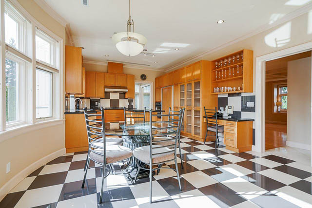 Bright kitchen with checkered floor and modern cabinets, featuring a central island and ample counter space. - 1128 W 49th, Vancouver West Side