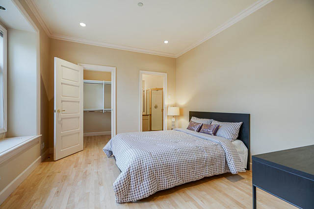 Spacious bedroom with hardwood floors and a cozy bed setup. - 1128 W 49th, Vancouver West Side