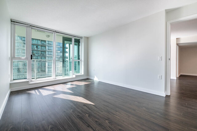 Spacious living room with hardwood floors and a city view. - 704-188 East Esplanade, North Vancouver