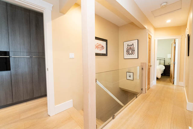 Spacious hallway with glass stair railing and light wood flooring. - 2128 Grand Blvd, North Vancouver