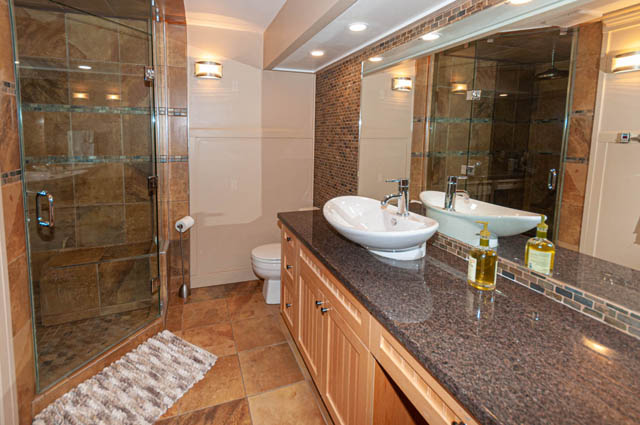 Spacious bathroom with granite countertops, modern sink, and glass shower enclosure. - 2128 Grand Blvd, North Vancouver