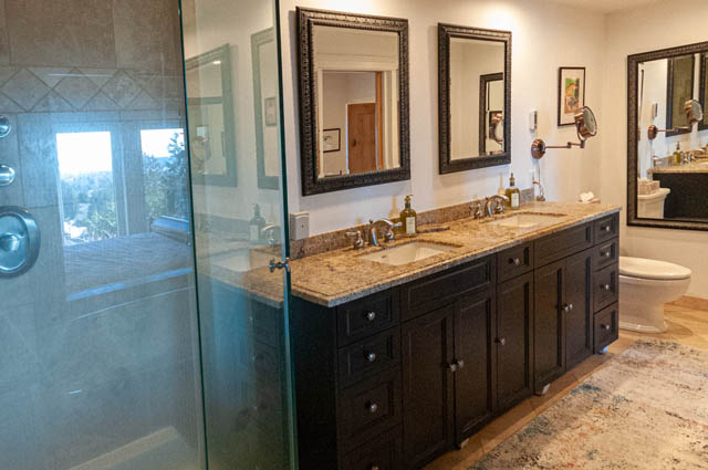 Spacious bathroom with granite countertops, black cabinetry, and a glass-enclosed shower. - 2128 Grand Blvd, North Vancouver
