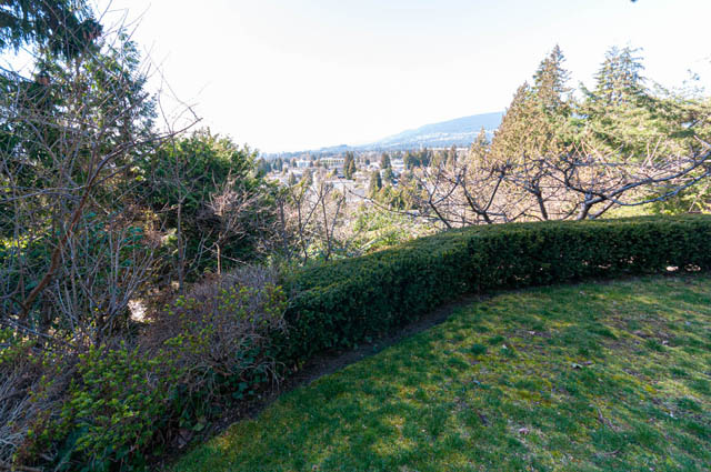 Spacious living room with a stunning city view and lush greenery. - 2128 Grand Blvd, North Vancouver