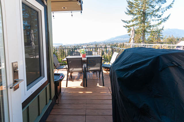 Furnished balcony with wooden deck, city view, and outdoor seating. - 2128 Grand Blvd, North Vancouver