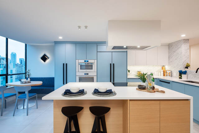 Bright kitchen with light blue cabinets, white countertops, and a city view. - 1402 - 738 Broughton St, Vancouver Downtown