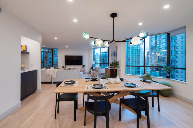 Furnished dining area with hardwood floors, city view, and modern lighting. - 1402 - 738 Broughton St, Vancouver Downtown