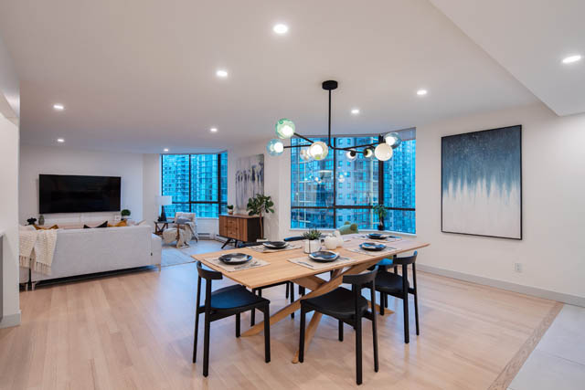 Open-concept living and dining area with hardwood floors, modern chandelier, and city view. - 1402 - 738 Broughton St, Vancouver Downtown