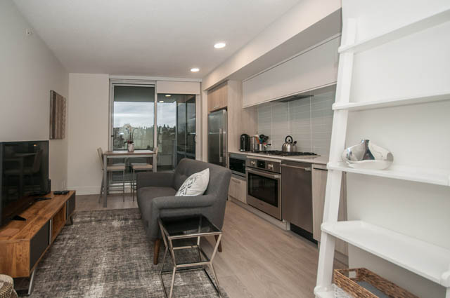 Bright living room with city view and modern furnishings. - 907 - 680 Seylynn Crescent, North Vancouver