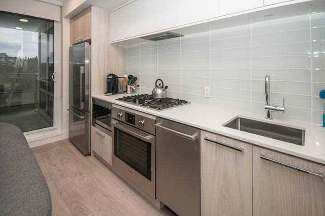 Bright kitchen with modern appliances, white subway tile backsplash, and hardwood floors. - 907 - 680 Seylynn Crescent, North Vancouver