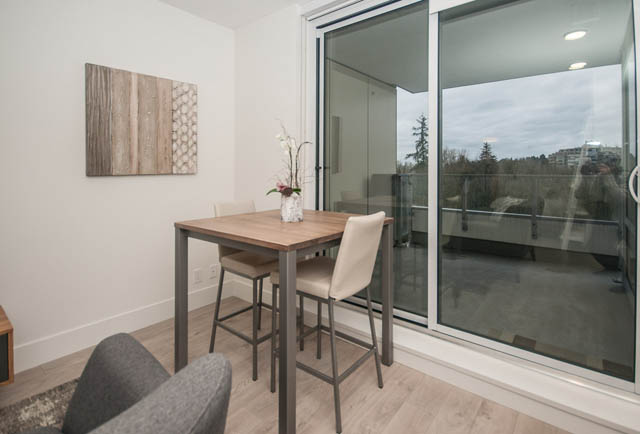 Furnished dining area with city view, hardwood floors, and modern decor. - 907 - 680 Seylynn Crescent, North Vancouver
