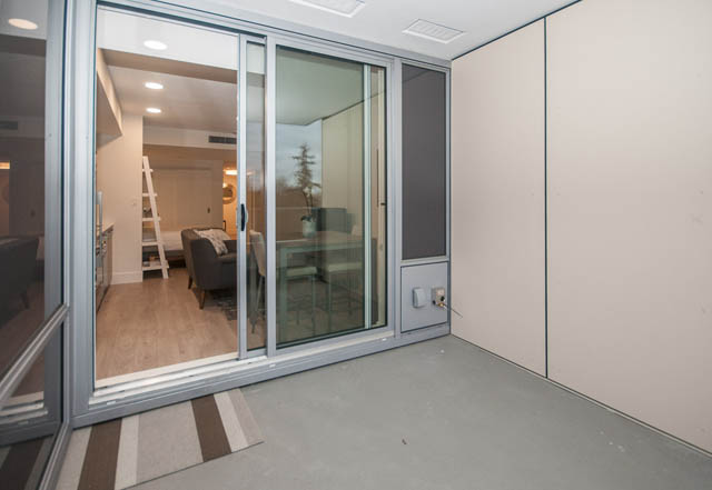 Bright living room with sliding glass doors, hardwood floors, and city view. - 907 - 680 Seylynn Crescent, North Vancouver
