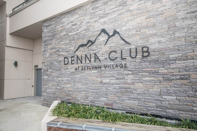 Furnished condo with stone facade and mountain logo. - 907 - 680 Seylynn Crescent, North Vancouver