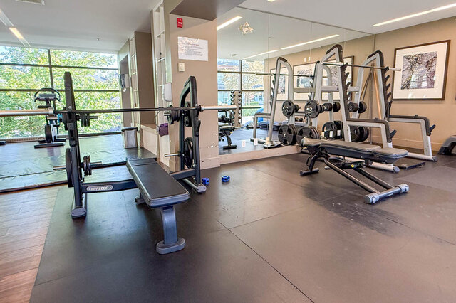 Gym featuring weight machines and large windows with tree views. - 504-3602 Aldercrest Drive, North Vancouver