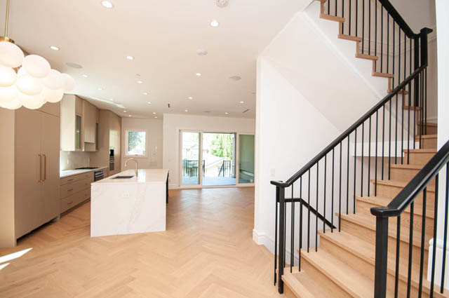 Bright kitchen with white quartz counters and herringbone hardwood floors in modern duplex. - 5909 Athlone Street, Vancouver West Side