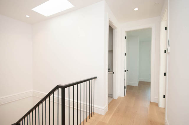 Spacious hallway with light wood flooring and modern black railings. - 5909 Athlone Street, Vancouver West Side