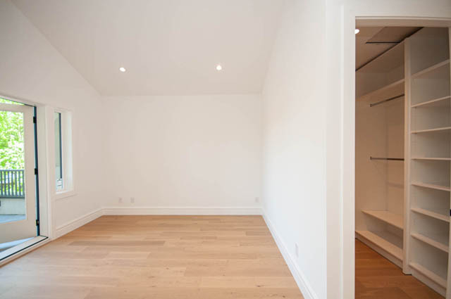Bright bedroom with light hardwood floors and built-in closet shelving. - 5909 Athlone Street, Vancouver West Side