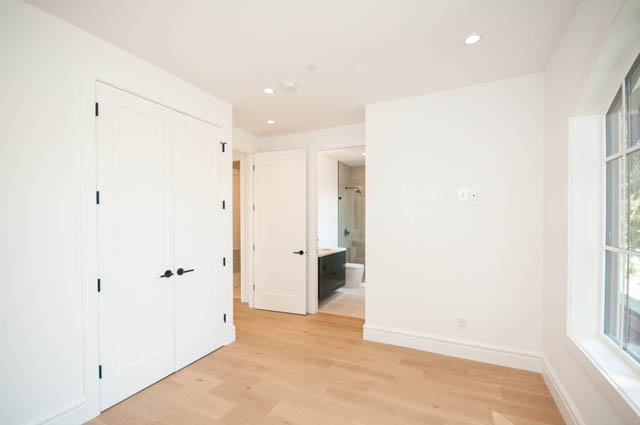 Spacious bedroom with light hardwood floors and large windows overlooking greenery. - 5909 Athlone Street, Vancouver West Side