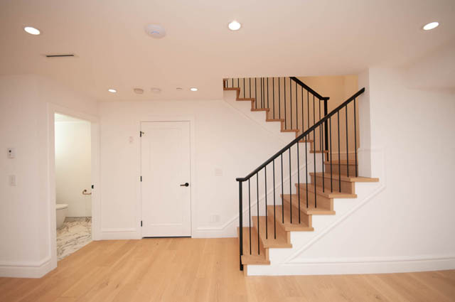 Spacious entryway with light wood hardwood floors and elegant black metal staircase railing. - 5909 Athlone Street, Vancouver West Side