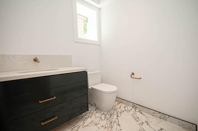 Modern bathroom with sleek black vanity, copper fixtures, and marble flooring. - 5909 Athlone Street, Vancouver West Side