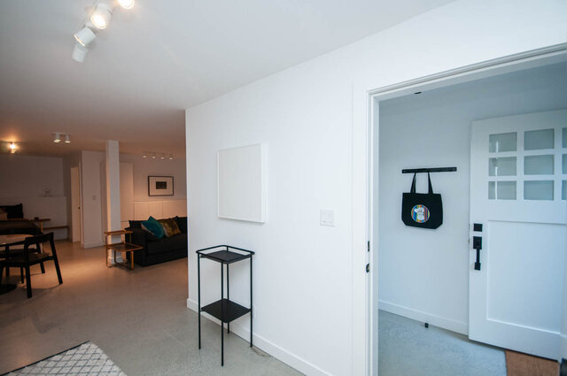 Modern living room with minimalist decor, white walls, and a cozy seating area. - 2 - 563 Union Street, Vancouver East Side