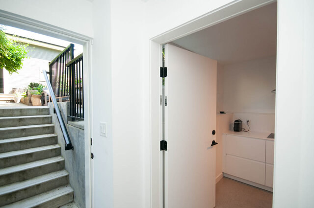 Bright laundry room with white cabinets and a view of the backyard. - 2 - 563 Union Street, Vancouver East Side