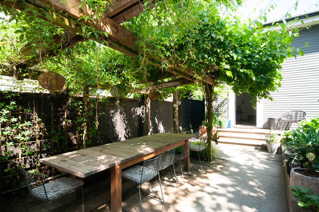 Cozy patio with wooden pergola and hanging plants, perfect for outdoor dining. - 2 - 563 Union Street, Vancouver East Side
