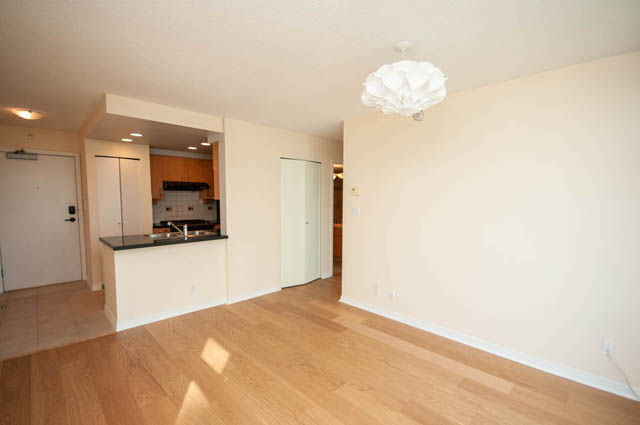 Bright kitchen with black countertops and hardwood floors. - 1105 - 198 Aquarius Mews, Vancouver Downtown