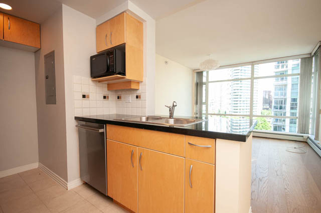 Bright kitchen with black countertops and city view. - 1105 - 198 Aquarius Mews, Vancouver Downtown