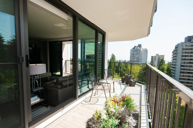 Spacious balcony with wood decking, outdoor dining set, and a high-rise city view. - 1006-4165 Maywood Street, Burnaby