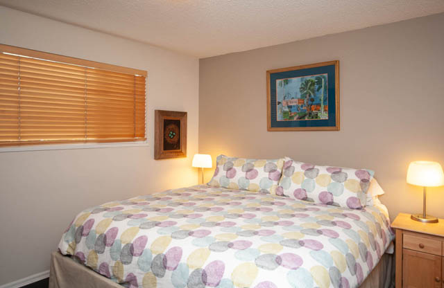 Furnished bedroom with two twin beds, patterned bedding, and bedside lamps. - 2077 W 13th Ave, Vancouver West Side
