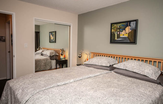 Spacious bedroom with twin beds, neutral decor, and artwork on the wall. - 2077 W 13th Ave, Vancouver West Side