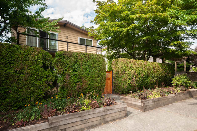 Furnished living room with wooden door and lush greenery. - 2077 W 13th Ave, Vancouver West Side
