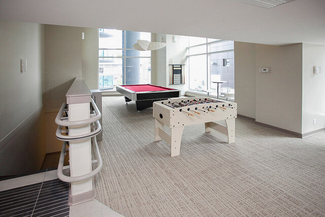 Game room with foosball table and pool table, large windows offering city views. - 1601 - 788 Hamilton Street, Vancouver Downtown