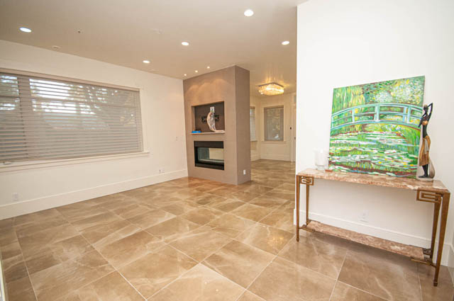 Spacious living room with marble countertops and a serene painting of a bridge. - 4504 West 12th Ave, Vancouver West Side